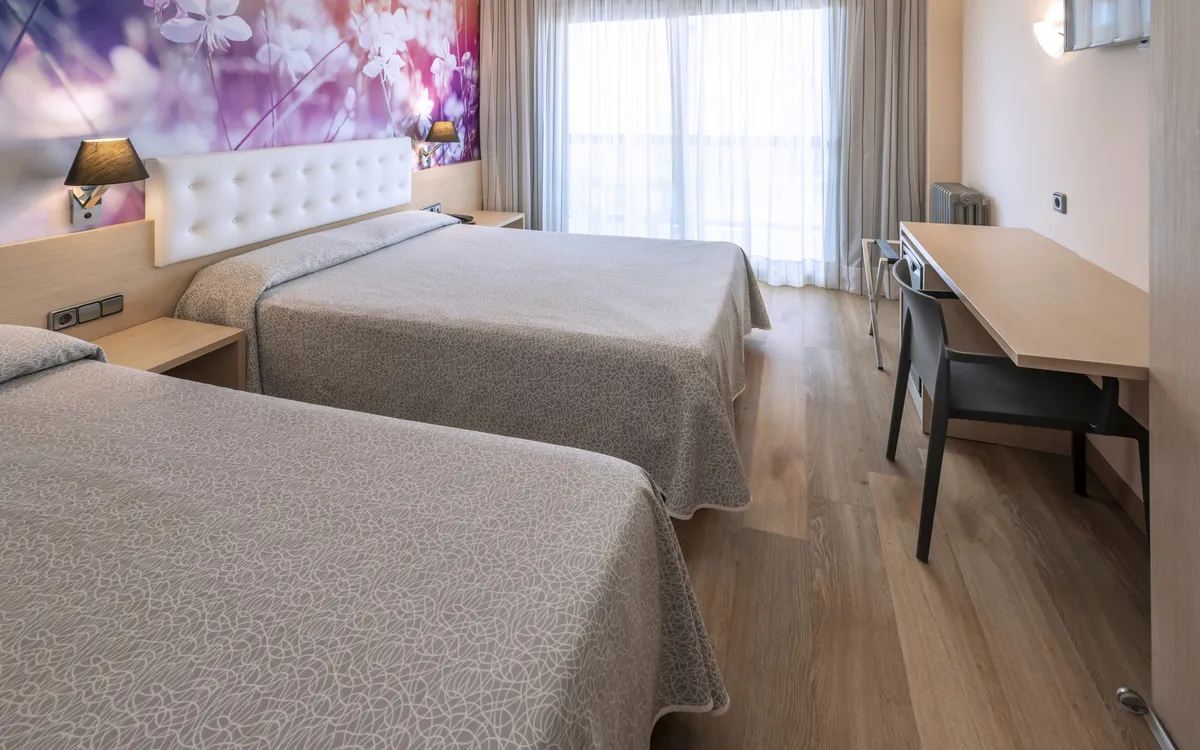 Ein sehr modern ausgestattetes Dreibettzimmer mit einem Doppelbett und einem Einzelbett.